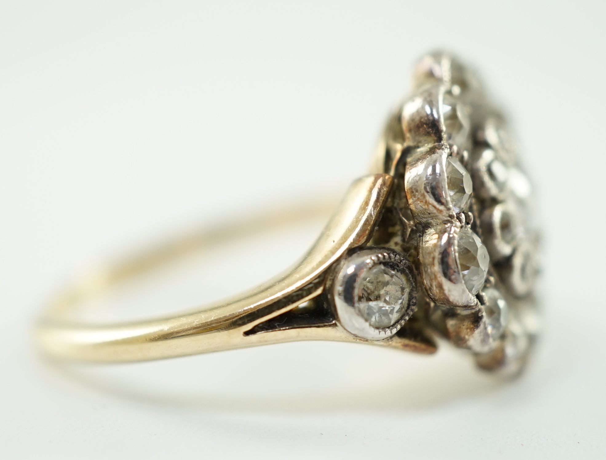 A mid 20th century gold and millegrain set diamond cluster target ring